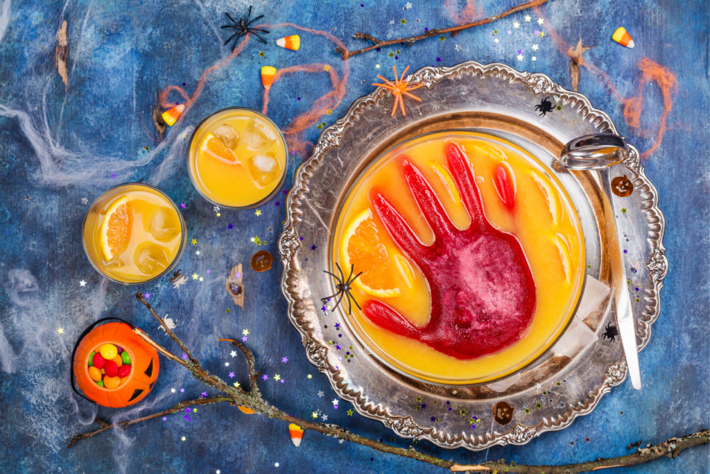 A punch bowl with a frozen red hand for a Halloween party.