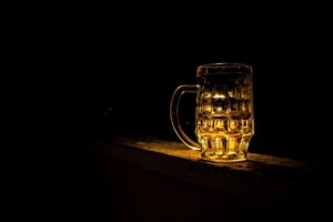 A mug of alcohol in a dark room.