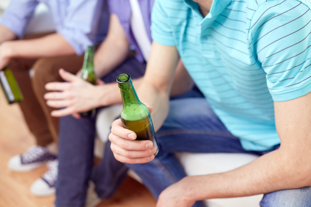 A teenage boy drinking alcohol underage.