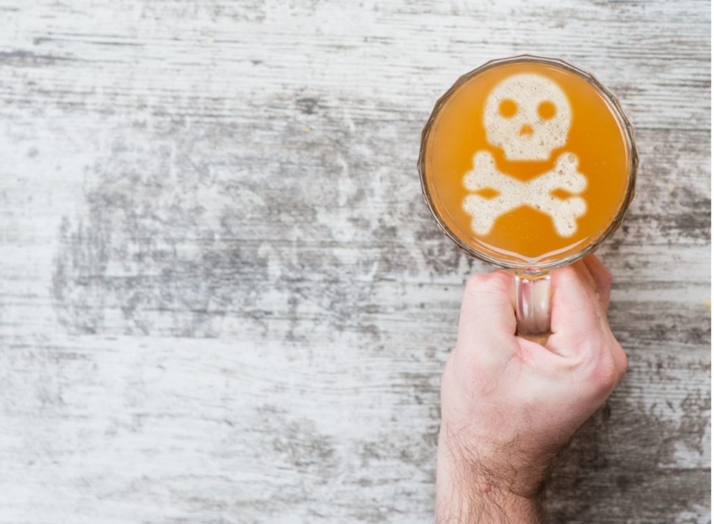 Glass of alcohol with skull and crossbones. 