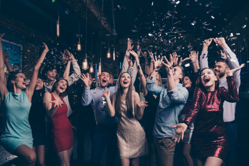 Young people at a party dressed nicely with confetti falling down